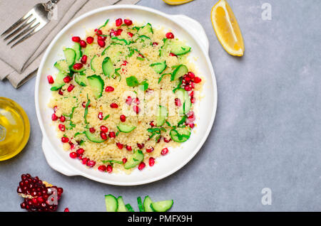 Couscous Salat mit Granatapfel, Minze und Gurken, gesunde Hausmannskost, vegane Mahlzeit Stockfoto