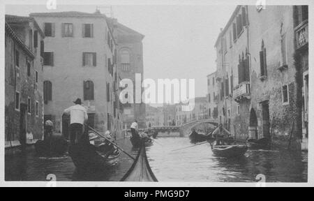 Schwarz-weiß Foto auf Karton, mit einem Bild von mehreren Gondolieri, Gondeln navigieren, einige Passagiere tragen Viktorianische Kleidung, andere Güter befördern, sind durch einen venezianischen Kanal (wahrscheinlich der Canal Grande) mit Gebäuden auf beiden Seiten sichtbar, und eine Brücke im Hintergrund, die wahrscheinlich als touristische Souvenir während einer Reise nach Venedig, Italien, 1910 gesammelt. () Stockfoto