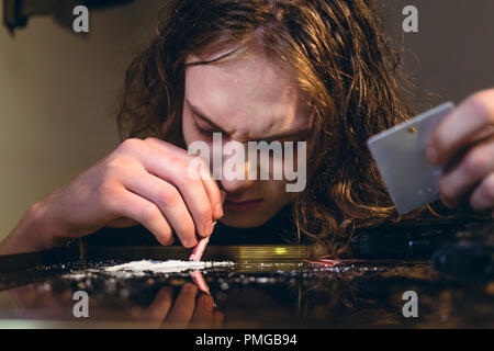 Droge Teenager halten einen gerollten Bill während snorting süchtig Stockfoto