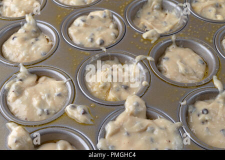 Chocolate Chip muffin Teig in eine kleine mini Backform, die mit Stick Cooking Spray besprüht wurde. Stockfoto