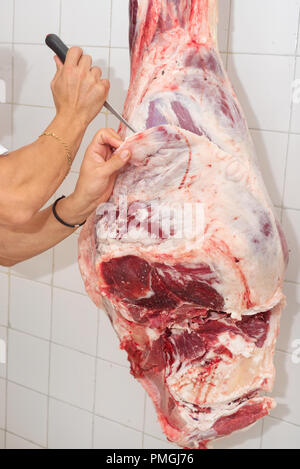 Metzger schneiden von Fleisch in der Metzgerei. Nahaufnahme Stockfoto