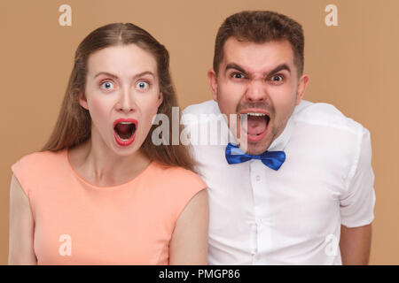 Closeup Portrait von Crazy schöner Mann und schöne Frau oder junges Paar schreien und Kamera mit entsetzten Gesicht. indoor Studio shot, isol Stockfoto