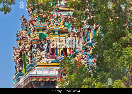 MEENAKSHI TEMPEL MADURAI Tamil Nadu Indien Statuen von Dämonen und Götter AUF EINEM TEMPEL TURM UND immergrünen Baum Stockfoto