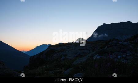 SUV 4x4 Auto auf Berggipfel, die malerische Landschaft bei Sonnenuntergang, Abenteuer exploration Wanderlust auf die Alpen. Stockfoto