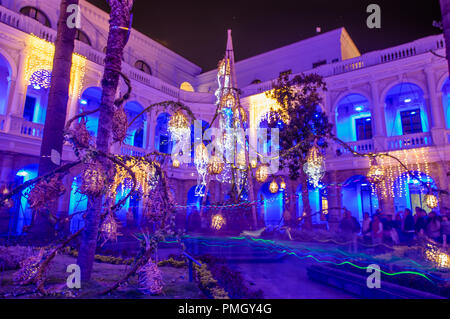 QUITO, ECUADOR - August, 15, 2018: Indoor Ansicht von Menschen mit Bildern in der kolonialen Gebäude mit bunten Lichtern während des Quito licht Festival Stockfoto