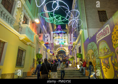 QUITO, ECUADOR - August, 15, 2018: unbekannte Menschen zu Fuß in einer engen Straße in ein Spektakel der Lichter auf den Wänden mit einigen beleuchteten Figuren während der Quito licht Festival projiziert Stockfoto