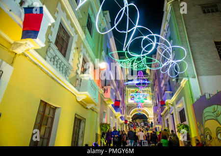 QUITO, ECUADOR - August, 15, 2018: die Masse von Menschen zu Fuß in einer engen Straße in ein Spektakel der Lichter auf den Wänden mit einigen beleuchteten Figuren während der Quito licht Festival projiziert Stockfoto