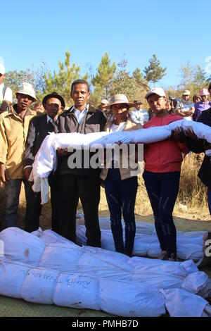 Masiniloharano, Madagaskar. 25 Aug, 2018. Eine Familie hält die Überreste eines Verwandten in Handtücher in die Hände gewickelt. Während der 'Famadihana' (wörtlich: Drehen der Knochen) Zeremonie, Menschen in Madagaskar betet an den Knochen ihrer Vorfahren. Sie sind aus ihren Gräbern, vor allem für die großen Festivals. (Dpa "Tanz mit den Toten: Happy Corpse Festival in Madagaskar" vom 19.09.2018) Credit: Jürgen Bätz/dpa/Alamy leben Nachrichten Stockfoto