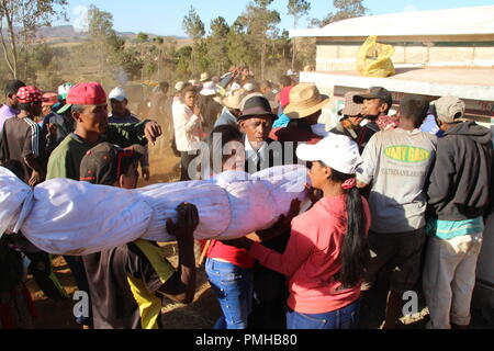 Masiniloharano, Madagaskar. 25 Aug, 2018. Verwandte tragen Bundles mit der sterblichen Überreste ihrer Vorfahren in eine Familie Grab verpackt. Während der 'Famadihana' (wörtlich: Drehen der Knochen) Zeremonie, Menschen in Madagaskar betet an den Knochen ihrer Vorfahren. Sie sind aus ihren Gräbern, vor allem für die großen Festivals. (Dpa "Tanz mit den Toten: Happy Corpse Festival in Madagaskar" vom 19.09.2018) Credit: Jürgen Bätz/dpa/Alamy leben Nachrichten Stockfoto