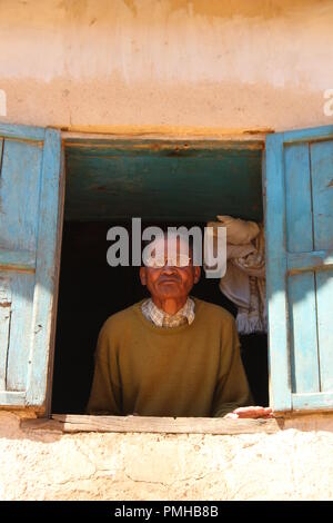 Masiniloharano, Madagaskar. 25 Aug, 2018. Das Dorf Astrologe Jean-Pierre Ralaizandry steht am Fenster seines Hauses. Nur der Astrologe kann mit dem Zeitpunkt des 'Famadihana' Zeremonie gesetzt (wörtlich: Drehen der Knochen). Während der Zeremonie, die Menschen in Madagaskar betet an den Knochen ihrer Vorfahren. Sie sind aus ihren Gräbern, vor allem für die großen Festivals. (Dpa "Tanz mit den Toten: Happy Corpse Festival in Madagaskar" vom 19.09.2018) Credit: Jürgen Bätz/dpa/Alamy leben Nachrichten Stockfoto