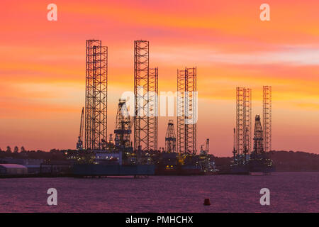 Jack-up-Bohrinseln für die Öl- und Gasindustrie im Hafen von Dundee, Schottland. UK Wetter Sep 2018. Der farbenfrohe Start in den Tag beginnt an den Tayside Docks, wo an der Flussmündung des Flusses Tay drei Aufbockanlagen und Bohrinseln in Betrieb genommen und gewartet werden. Die Verlangsamung der Öl- und Gasindustrie in der Nordsee hat dazu geführt, dass Bohrinseln aus der Nordsee entfernt wurden, wobei die Dundee docklands ihnen eine Anlegestelle bieten, bis sie in Zukunft wieder benötigt werden. Kredit; MediaWorldNews/AlamyLiveNews. Stockfoto