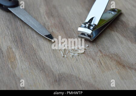 Clipper und Nagelfeile auf Holzbrett Stockfoto