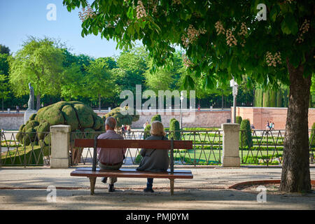 Reifes Paar sitzt auf der Bank im Park (Parque del Buen Retiro in Madrid, Spanien) Stockfoto