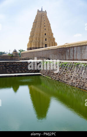 Die neun-tiered Eastern Gateway (Gopuram) und ihre Reflexion in der pushkarani (Tempel Tank) bei virupaksha Temple, Hampi, Karnataka, Indien Stockfoto