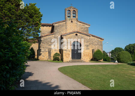 Alte Kirche von San Julian de los Prados mit Bäumen und blauer Himmel, Oviedo, Spanien Stockfoto