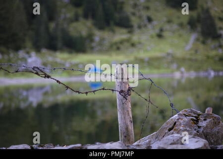 Ein Stacheldraht blockiert den Weg zum See Stockfoto