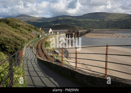 Eine Dame Walker auf der Barmouth Fußgänger- und Eisenbahnbrücke an der Mündung des Mawddach, am 13. September 2018, in Pwllheli, Gwynedd, Wales. Stockfoto