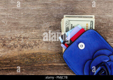 Kreditkarte und Dollar in der Brieftasche auf Holz- Hintergrund. Ansicht von oben. Stockfoto