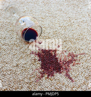 Glas Rotwein fiel auf dem Teppich, Wein auf dem Teppich verschüttet Stockfoto