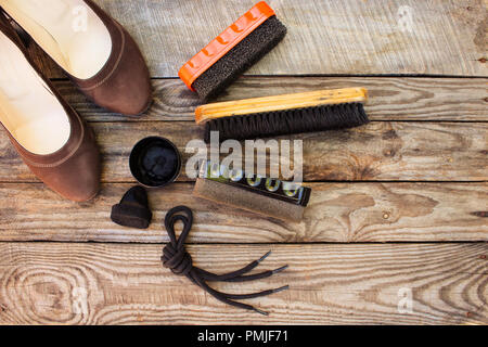 Schuhe und Pflegemittel für Schuhe auf Holz- Hintergrund. Getönten Bild. Ansicht von oben. Stockfoto