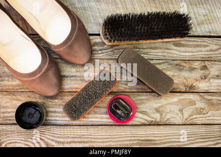 Damenschuhe und Pflege für Schuhe auf Holz- Hintergrund. Stockfoto