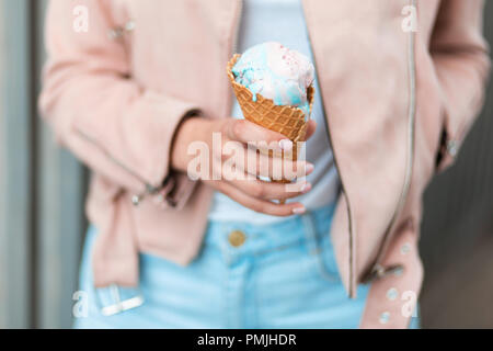 Schöne Frau mit Eis. In den Farben Pink und Blau Stockfoto