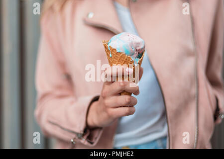 Köstliche rosa und blau Eis. Mädchen hält einen Wafer Kegel mit Eis Stockfoto