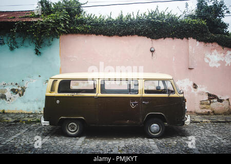 Braun und Creme retro Wohnmobil aus den 1970er Jahren entlang einer Straße mit Kopfsteinpflaster mit Pastell rosa und blaue Wände geparkt Stockfoto