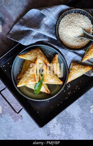 Frisch gebackene Spanakopita Dreiecke gefüllt mit Spinat und Feta Käse Stockfoto