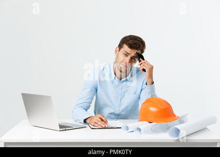 Ernster mann Kaufmann oder Ingenieur sitzen in Baustelle. Mutige im mittleren Alter Mann sitzen mit traurigen, schwerwiegenden und deprimierten Gesichtsausdruck. Stockfoto
