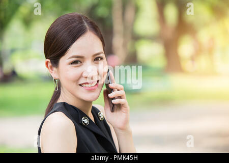 Business Mädchen Aufruf Outdoor Kamera schauen und lächeln. Stockfoto