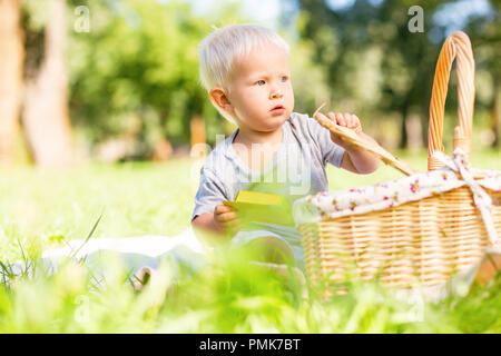 Schwere kleine Zicklein, die versuchen, Bonbons in den Korb zu finden Stockfoto