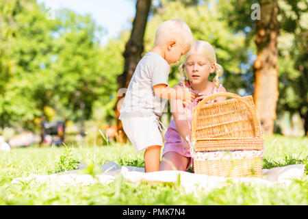 Süße Junge und Mädchen etwas aus dem Korb Stockfoto