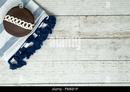 Schokolade wirbelte Cupcake mit blau serviette auf Holz Hintergrund eingerichtet Stockfoto