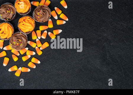 Halloween cupcake Anordnung Hintergrund mit Schokolade Kuchen und Süßigkeiten Mais Stockfoto