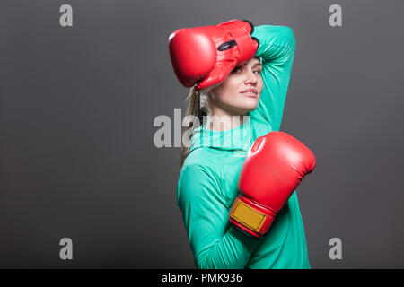 Portrait von Freude, schöne junge Athlet Frau mit gesammelten Haare stehen in Position, Hand in Boxen roten Handschuhe zu Kopf und Stockfoto