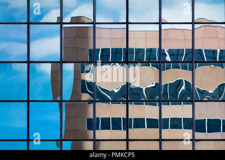 Architektur Detail in Bürogebäude, Birmingham, Alabama. Eine verzerrte Widerspiegelung eines Bürogebäudes in der reflektierenden Fenstern von einem anderen Büro blockieren. Stockfoto