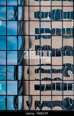 Architektur Detail in Bürogebäude, Birmingham, Alabama. Eine verzerrte Widerspiegelung eines Bürogebäudes in der reflektierenden Fenstern von einem anderen Büro blockieren. Stockfoto