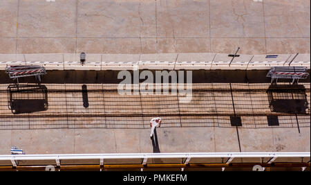 Marineoffizier, tragen weiße Uniform, zu Fuß in Richtung Schiff, Schatten neben ihm, Erhöhte Ansicht, der Hafen von Messina, Sizilien, Italien, Europa Stockfoto