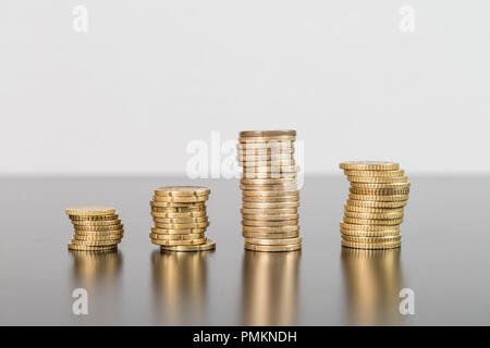 Stapel von Münzen, die auf eine Tabelle auf weißem Hintergrund Stockfoto