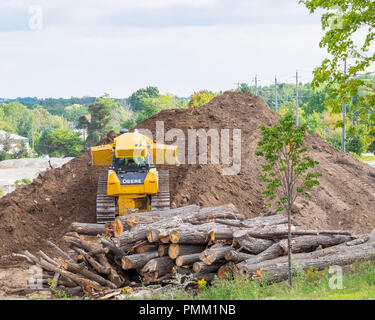 Eine Planierraupe schiebt Stapel des Schmutzes auf einer Baustelle arbeiten. Stockfoto