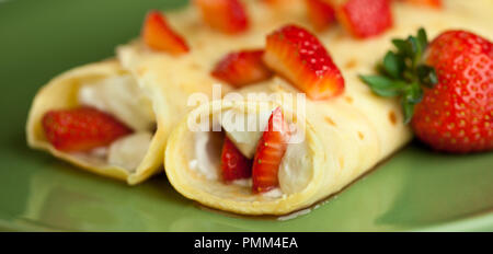 Erdbeere Crepes mit Sahne auf der grünen Platte Stockfoto