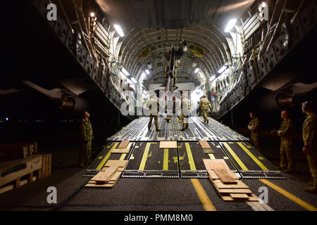 Us-Armee Soldaten aus der Alaska National Guard 1-207 th Aviation Medevac Loslösung, offload Ein UH-60 Black Hawk Hubschrauber von einem C-17 Globemaster III Cargo Aircraft aus Die 144 Airlift Wing, Alaska Air National Guard, 17. September 2018. Die medevac Team aus Joint Base Elmendorf, Alaska, kam an McEntire Joint National Guard Base, South Carolina, mit Such- und Rettungs- und Hilfsmaßnahmen während der Nachwirkungen des tropischen Sturms Florenz zu unterstützen. McEntire wird als ein Knotenpunkt für Flugzeuge stützende Wiederaufnahme Bemühungen in den Bereichen, in South Carolina von tropischen Stor beeinflusst Stockfoto