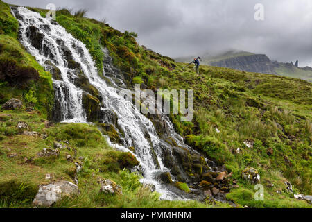 Fotograf wandern bis Bräute Schleier Wasserfälle an der Storr mit alten Mann von Storr Gipfel in Wolken auf der Isle of Skye Inneren Hebriden Schottland Großbritannien Stockfoto