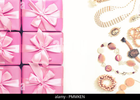 Reihen von Boxen mit Geschenke Dekoration Band satin schleife rosa Mode Accessoires für Damen Schmuck Perlenkette Armband. Ein Blick von Oben auf die Flach toning Stockfoto