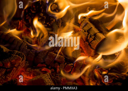 Brennende Holzkohle mit orangefarbenen Flammen im Kamin Stockfoto