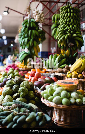 Tropische Frucht in traditionellen Körbe angezeigt auf einem Marktstand in Mercado dos Lavradores in Funchal. Stockfoto
