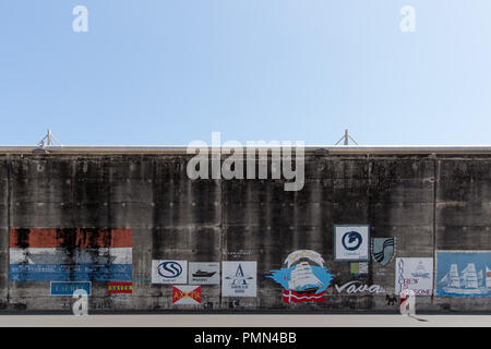 Anzeigen, Logos und Embleme auf einem hohen Betonmauer (das Meer Wand) entlang des Docks im Hafen von Funchal, Madeira lackiert Stockfoto