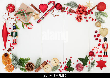 Weihnachten Hintergrund Grenze Komposition mit traditionellen Symbolen der Christbaumkugel Dekorationen, Zuckerstangen, Kuchen, Obst, Gewürze Gehacktes, winter Flora und Geschenk Stockfoto