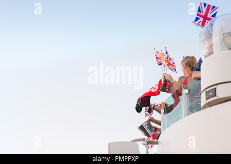 Britische Leute weg Winken der Union Jack Flagge und einem Waliser banner/Schal auf einem Kreuzfahrtschiff Segel Stockfoto